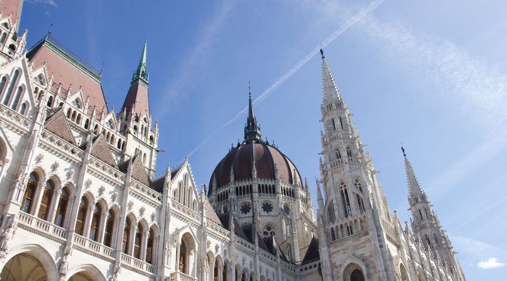 das Budapester Parlamentsgebäude von schräg utnen vor dem blauen Himmel fotografiert