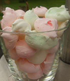 eine glasschüssel voller pastellrosa und - grüner baisers