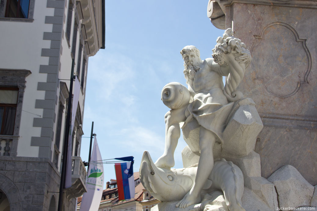 weiße statue an einem brunnen vor blauem himmel