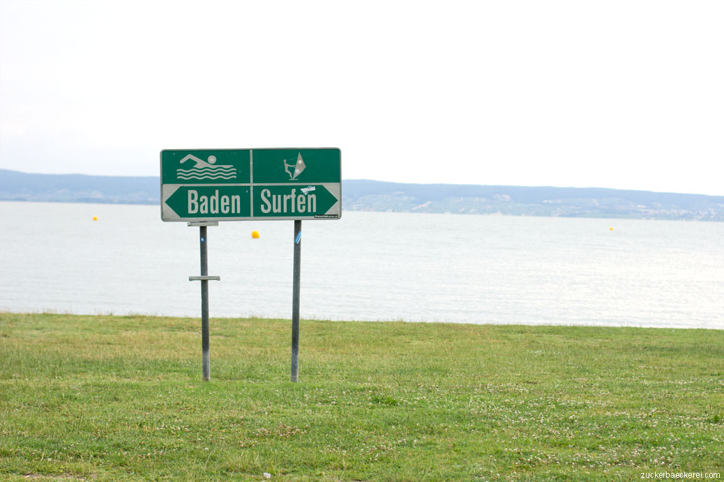 schild "baden surfen" auf einer wiese am ufer des neusiedlersees