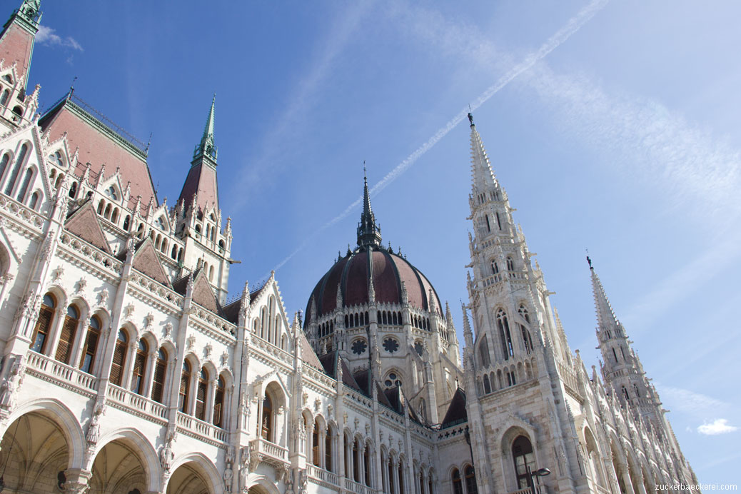 das Budapester Parlamentsgebäude von schräg utnen vor dem blauen Himmel fotografiert