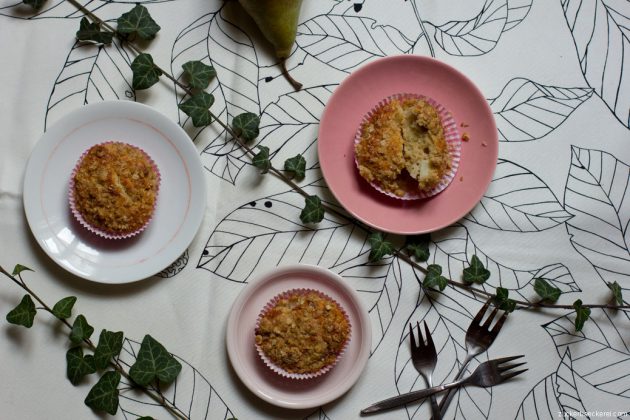 drei hafermuffins auf kleinen tellern auf weißer tischdecke, dazwischen efeuranken und kleine gabeln, vogelperspektive