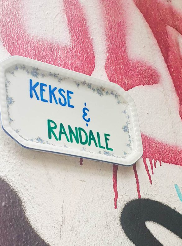 Teller mit der Beschriftung "Kekse & Randale" an einer Graffiti-Wand