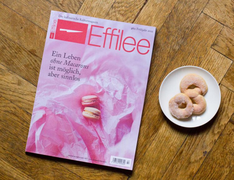 Die Effilee-Ausgabe 60 mit rosa Cover, auf dem zwei Macarons zu sehen sind, daneben ein kleiner Teller mit Kringel-Keksen mit rosa Zucker obenauf