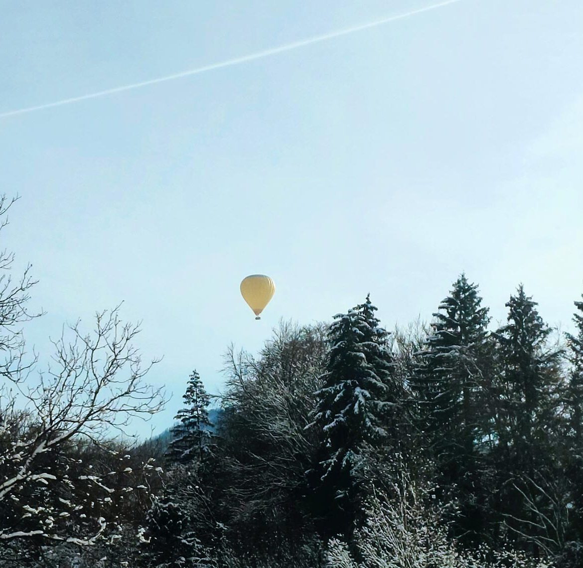 gelber heißluftballon am blauen winterhimmel