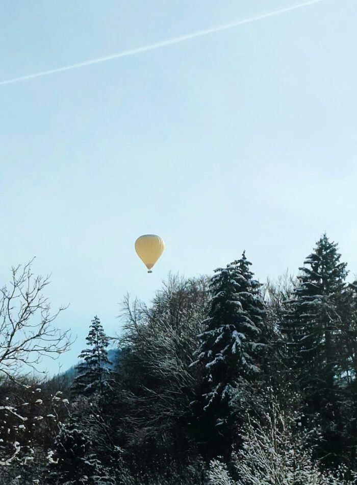 gelber heißluftballon am blauen winterhimmel