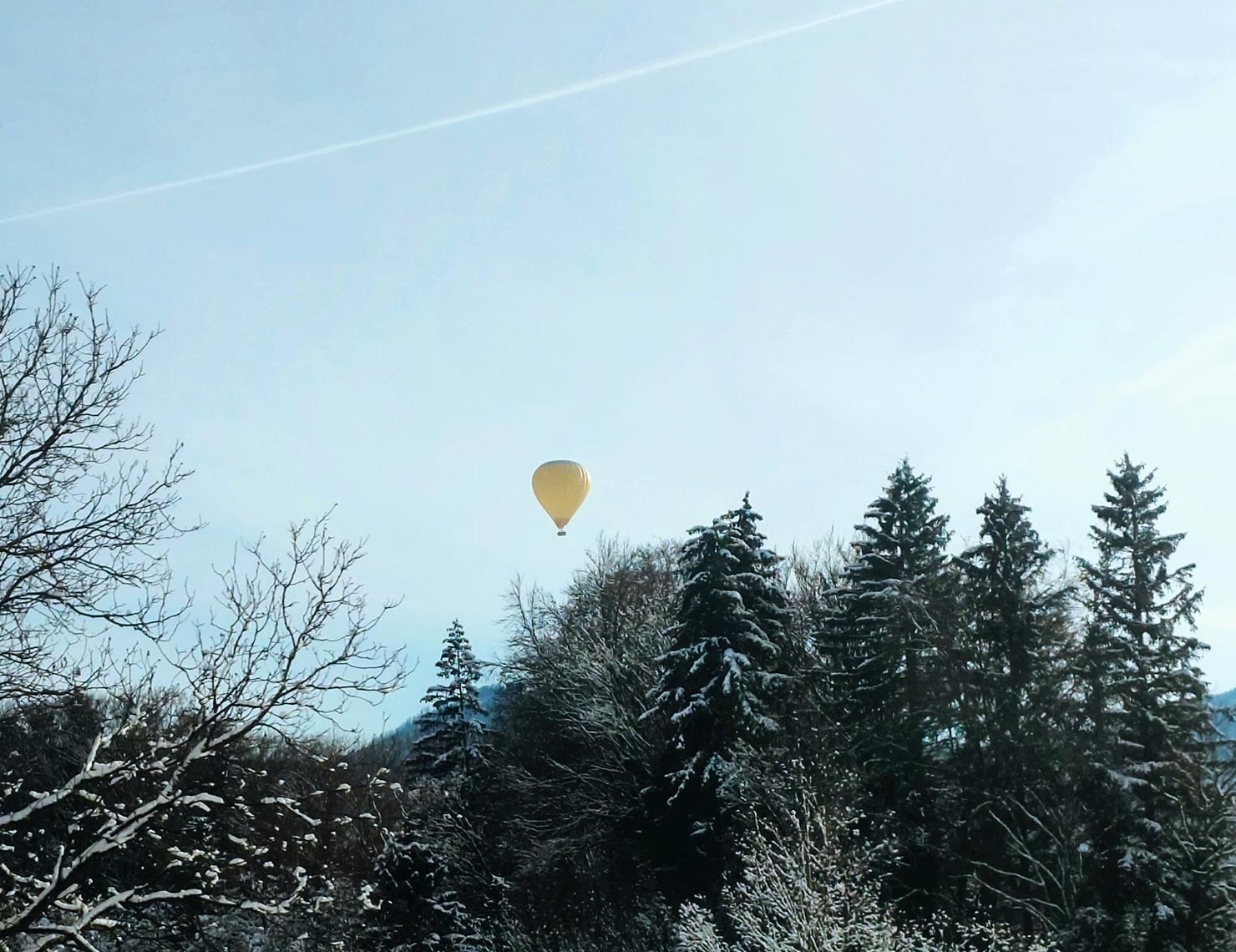 gelber heißluftballon am blauen winterhimmel