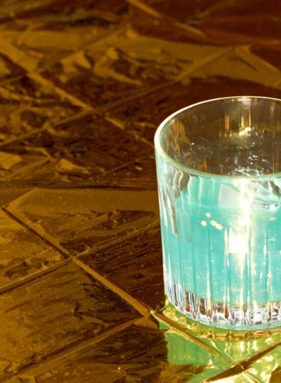 blauer cocktail auf goldener oberfläche