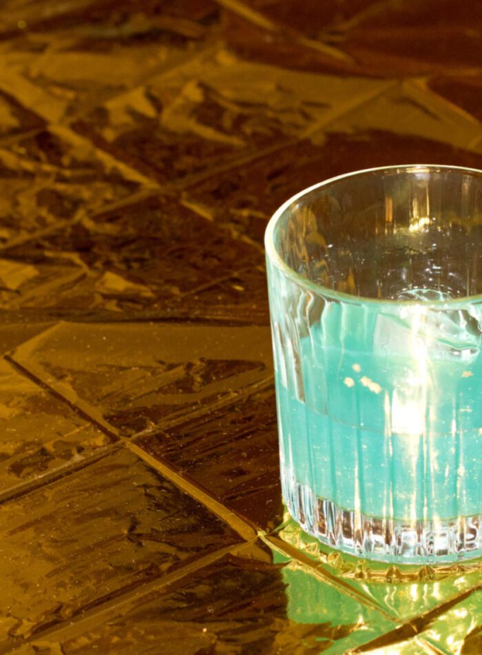 blauer cocktail auf goldener oberfläche