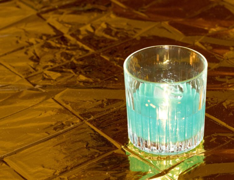 blauer cocktail auf goldener oberfläche