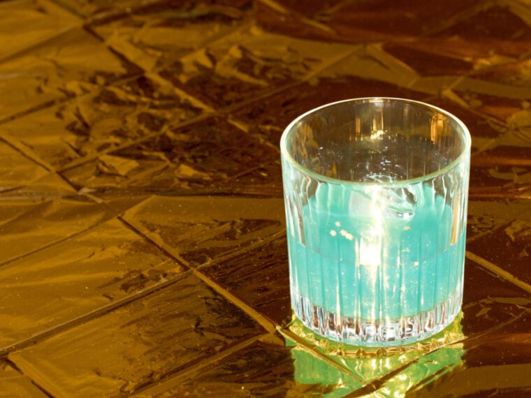 blauer cocktail auf goldener oberfläche