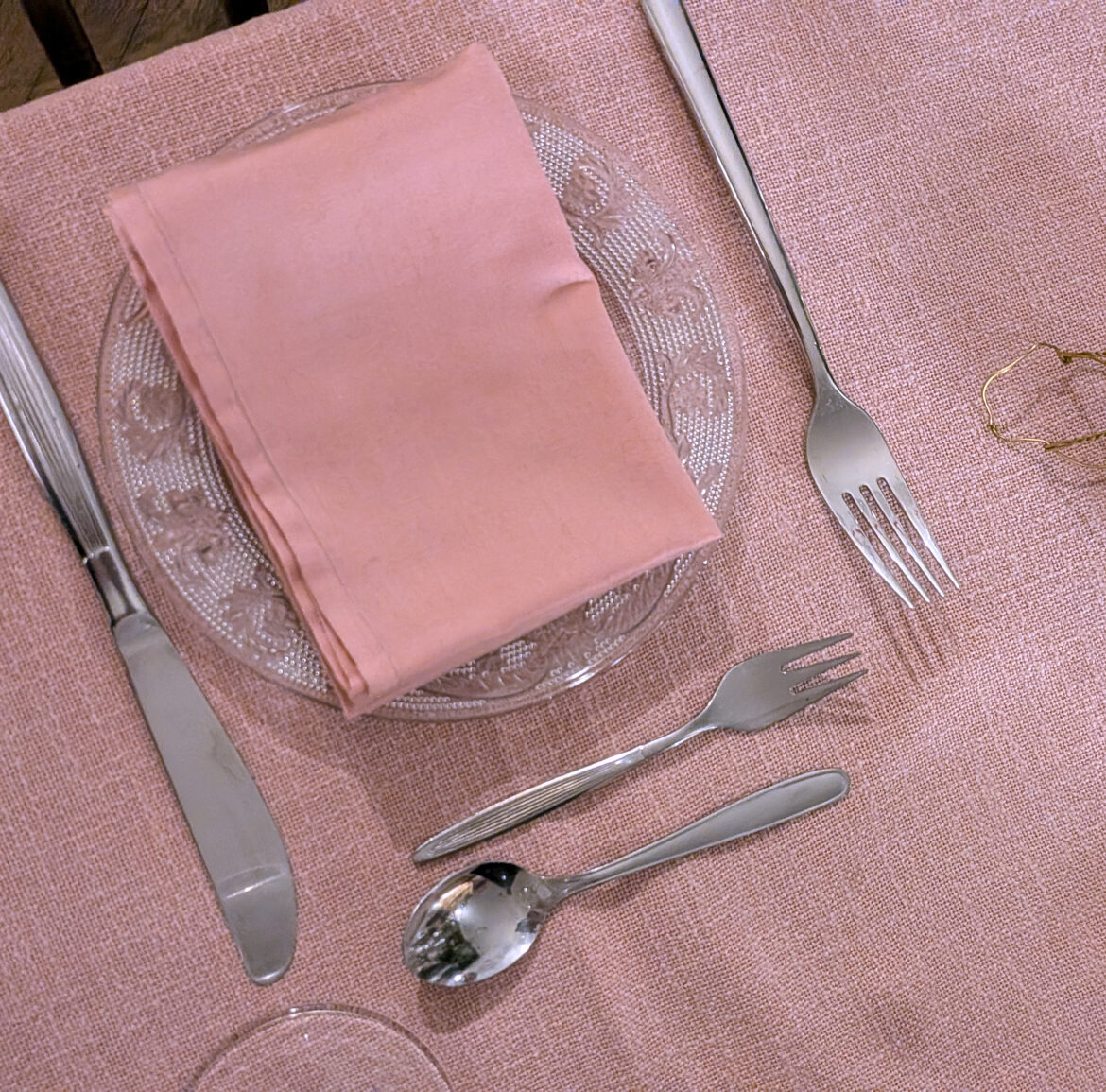 gedeckter Platz mit Rosa Geschirrtuch und Tischdecke