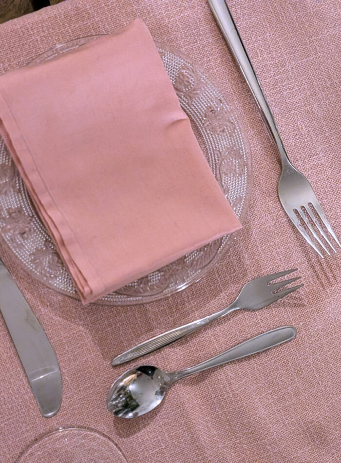 gedeckter Platz mit Rosa Geschirrtuch und Tischdecke