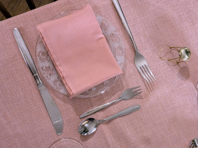 gedeckter Platz mit Rosa Geschirrtuch und Tischdecke